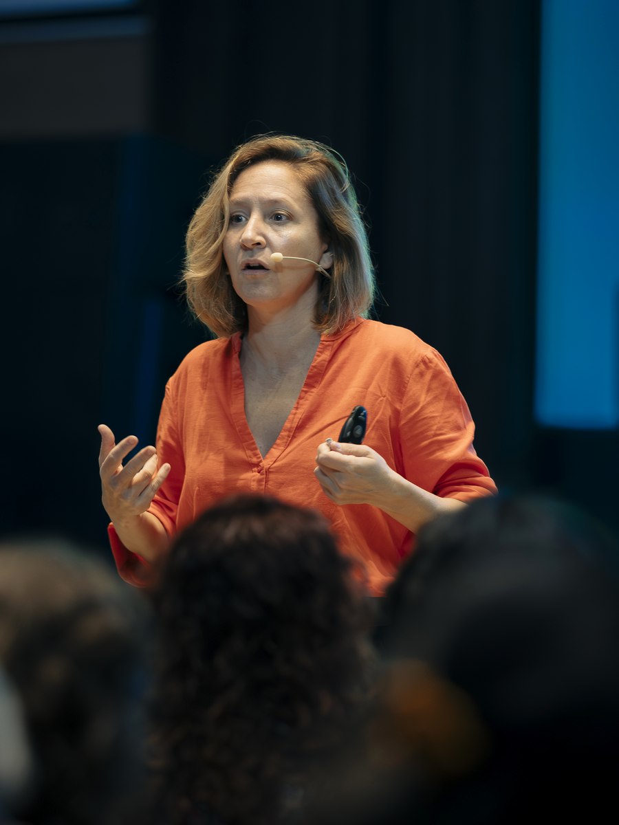 Primer plano de la Dra. María Roca hablando en una charla.